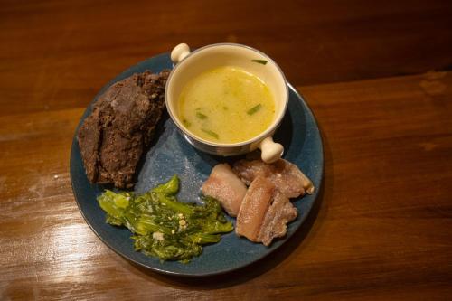 a plate of food with a bowl of soup and broccoli at Hoongla Inn - Homestay in Lumla Tawang in Kāmbāng