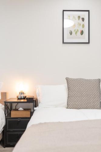 a bedroom with a bed and a nightstand with a picture at b&岸里店 in Osaka