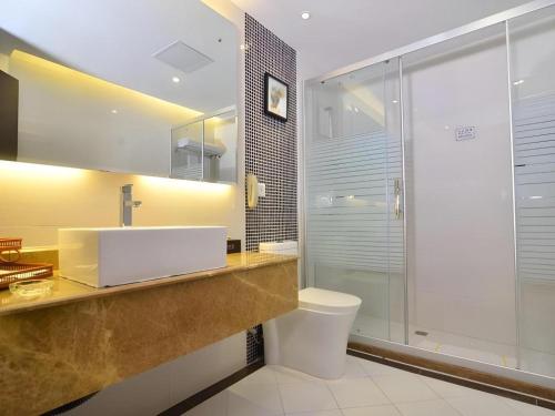 Un baño con lavabo, inodoro y ducha. en Landmark International Hotel Nanwan, en Zhuhai