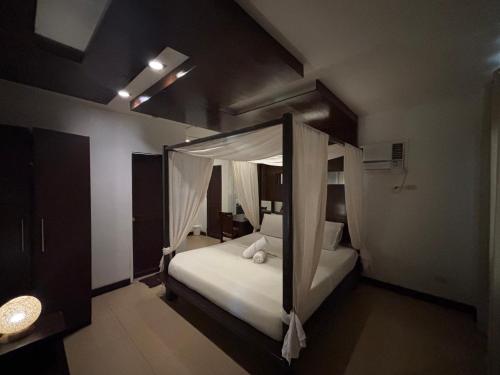 a bedroom with a canopy bed with white pillows at Seabird International Resort in Boracay
