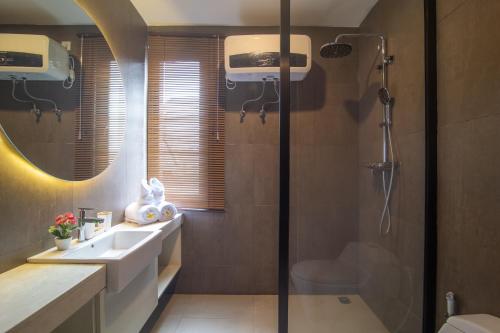 un baño con lavabo y ducha en Casa de la Vida, en Tanah Lot