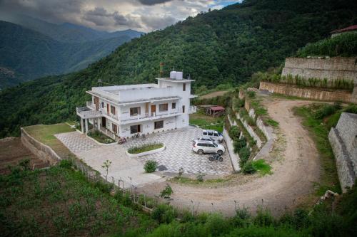 an aerial view of a house with a car parked in front at Hoongla Inn - Homestay in Lumla Tawang in Kāmbāng