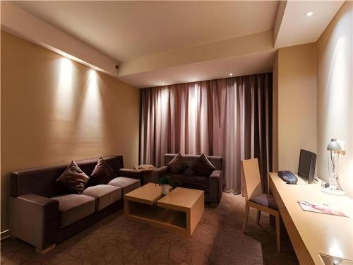 a living room with a couch and a table at Jinjiang Metropolo Hotel - Langfang Wanda Plaza in Langfang