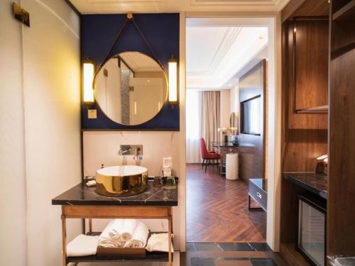 ein Badezimmer mit Waschbecken und Spiegel in der Unterkunft Metropolo Hotel Shijiazhuang Yuhua Wanda Plaza in Shijiazhuang