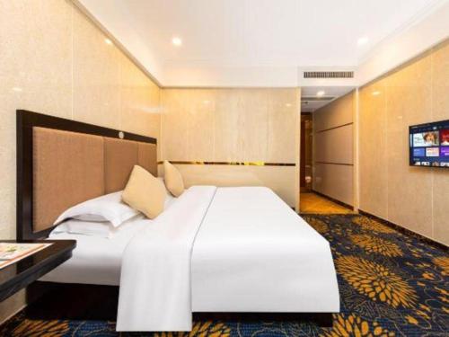 a large white bed in a hotel room at Zhongshan Hui Quan Hotel in Zhongshan