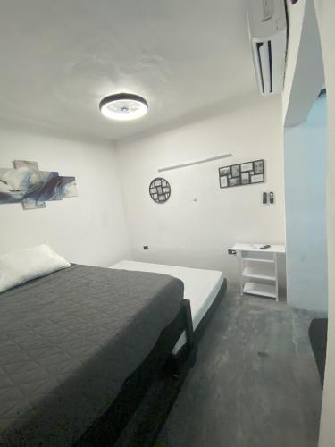 a white bedroom with a bed and a desk at DGM Lofts GPE 5 cerca estadio Rayados MTY in Monterrey