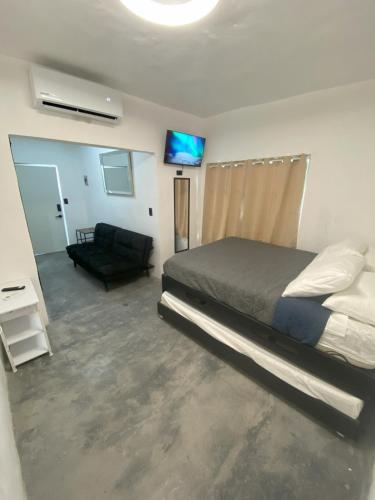 una camera da letto con un letto, un divano e una televisione di DGM Lofts GPE 5 cerca estadio Rayados MTY a Monterrey