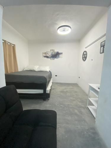 a bedroom with a bed and a couch in a room at DGM Lofts GPE 5 cerca estadio Rayados MTY in Monterrey