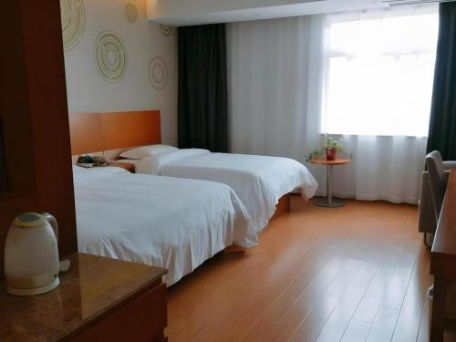 Ένα ή περισσότερα κρεβάτια σε δωμάτιο στο GreenTree Inn Anqing Yuexixian Wenquan Branch