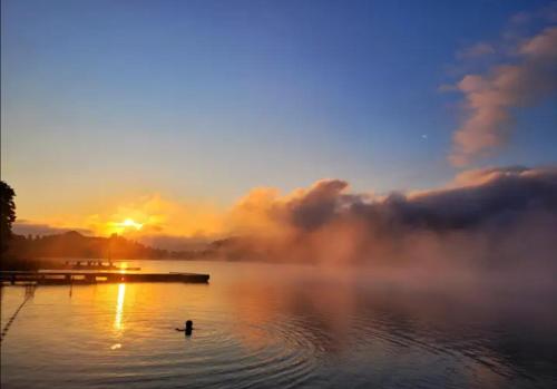 a person standing in the water at sunset at SeeSternchen in Faak am See