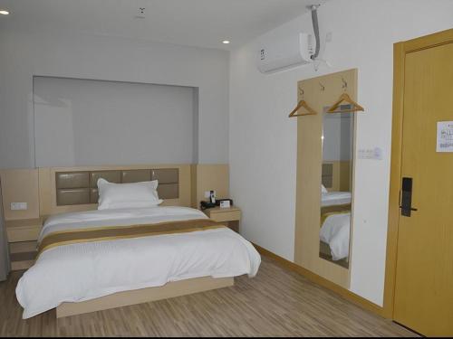 a bedroom with a large bed and a mirror at Shell Shanghai Jiading Nanxiang Town Minzhu Street Hotel in Shanghai
