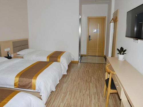 a hotel room with two beds and a television at Shell Shanghai Jiading Nanxiang Town Minzhu Street Hotel in Shanghai