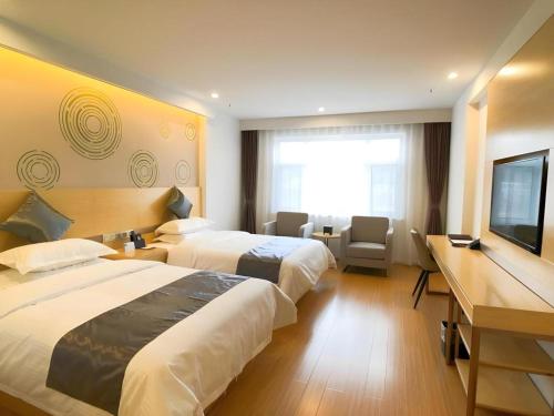 a hotel room with two beds and a flat screen tv at GreenTree Inn Chengde Shuangyu District Shuangtashan in Chengde