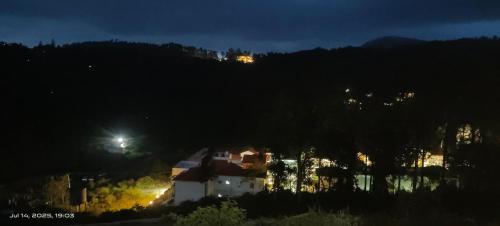 a house sitting on top of a hill at night at Sky View Resort in Yercaud