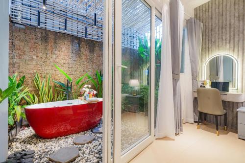 a bathroom with a red bath tub in a room at Cubicity Metro House in Ho Chi Minh City