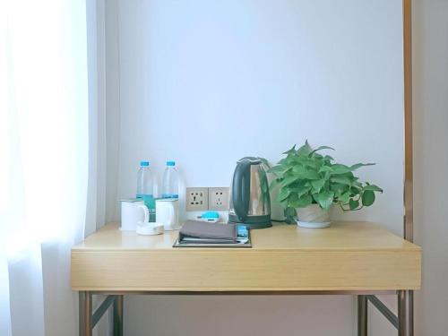 a wooden table with a plant on top of it at GreenTree Inn Express Gongqing City Nanchang University in Gongqingcheng
