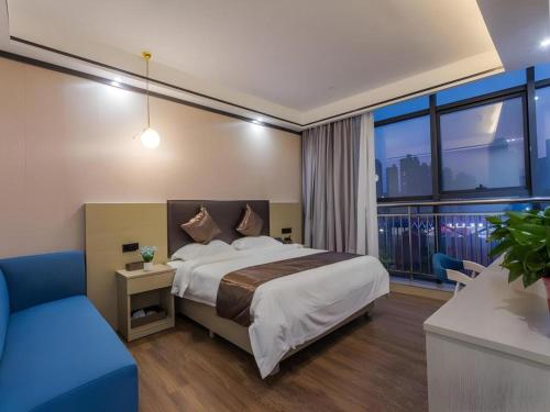 a bedroom with a large bed and a blue chair at GYA Changzhou Wujin District Hutang New Era Furniture Plaza Hotel in Changzhou