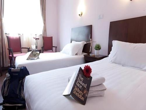 a hotel room with two beds with a sign on it at Shijia Inn On the Bund in Shanghai