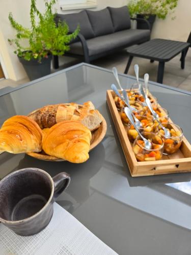 Les Tilleuls de Chapareillan Chambres d'hôtes في Chapareillan: طاولة عليها طبقين من الخبز وصينية من المعجنات