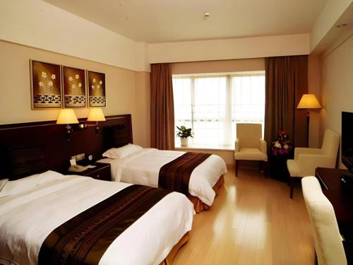 a hotel room with two beds and a window at GreenTree Inn Rizhao Haiqu East Road Hotel in Rizhao
