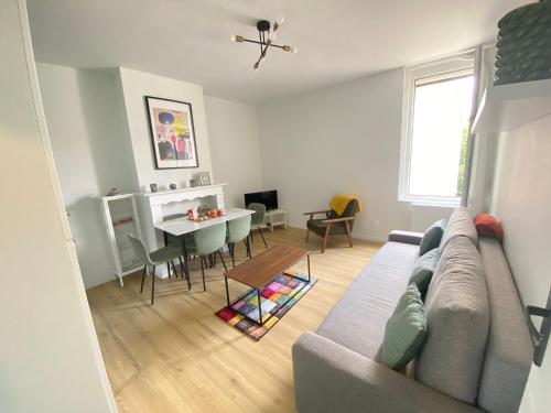 un salon avec un canapé et une salle à manger dans l'établissement Appt 6 couchages Jardin Parking laverie, à Dunkerque
