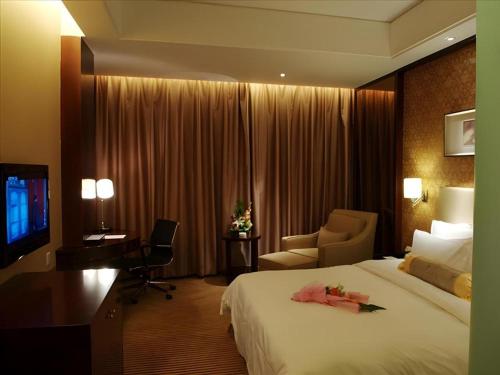 Postel nebo postele na pokoji v ubytování Yiwu Shinsun International Hotel