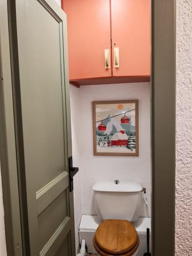 a bathroom with a toilet with a wooden seat at Le Bon' Appart studio proche centre Châtel in Châtel