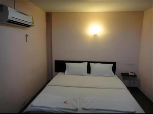 una camera da letto con un letto con lenzuola bianche e una luce sul muro di Ban Bua Resort and Hotel a Khon Kaen