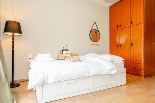 une chambre avec un lit blanc avec un ballon de basket au mur dans l'établissement Στούντιο δίπλα στο πανεπιστήμιο και το νοσοκομείο, à Ioannina