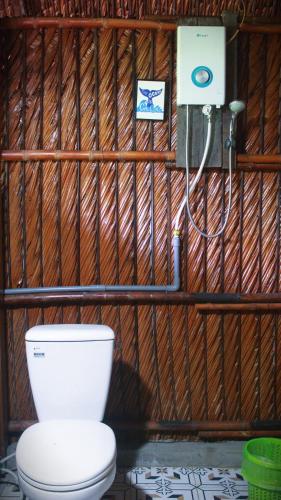 a bathroom with a toilet in a wooden wall at Saigon Garden Homestay in Ho Chi Minh City