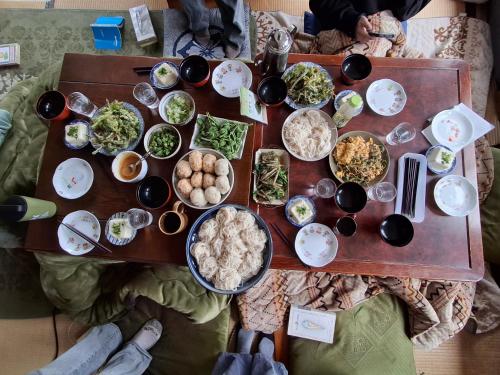 a table with a lot of food on it at わくわく自然体験の宿ゲストハウス山楽 in Itoigawa