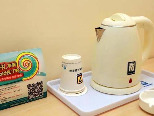 a white tea kettle on a tray next to a box at 7 Days Inn Chengdu Sichuan University South Railway Station in Chengdu