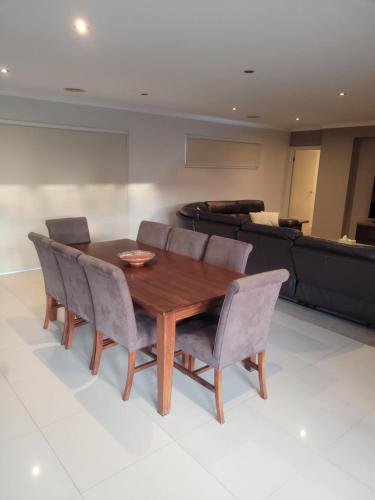 a dining room with a wooden table and chairs at The Mount Martha Hideaway in Mount Martha