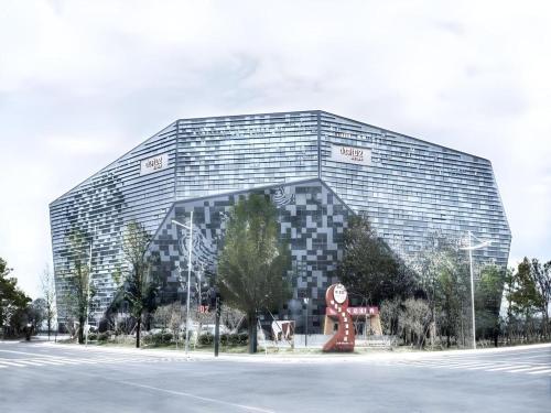 a large glass building with a statue in front of it at Dusit D2 Binhu Changzhou Hotel in Changzhou