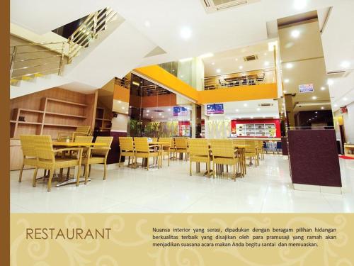 a restaurant with yellow chairs and tables in it at Borneo Hotel in Pontianak