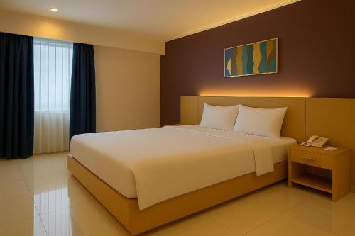 a bedroom with a white bed and a telephone at Borneo Hotel in Pontianak