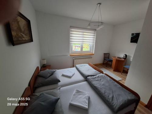 a bedroom with two beds and a window at Osada Chybotek in Przesieka