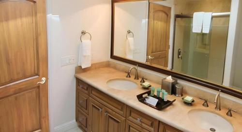 a bathroom with two sinks and a large mirror at Dolphin Bay Resort and Spa in Pismo Beach