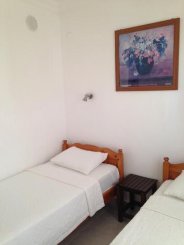 a bedroom with two beds and a picture on the wall at The White House Kalkan in Kalkan