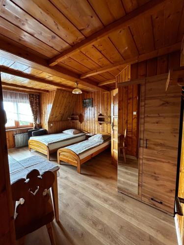 a bedroom with two beds in a wooden cabin at Cabanówka in Bukowina Tatrzańska