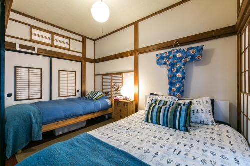 a bedroom with two beds and a cross on the wall at Samurai House - Large Family House, West Shinjuku in Tokyo