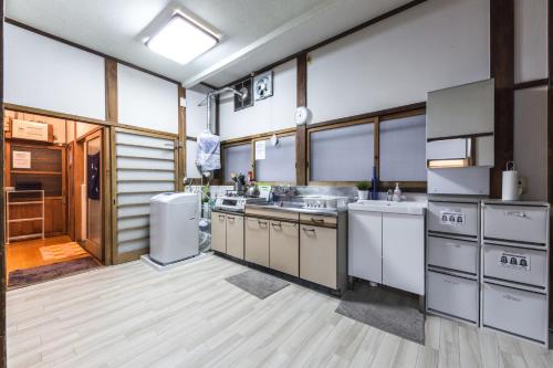 a large kitchen with white appliances and wooden floors at Samurai House - Large Family House, West Shinjuku in Tokyo