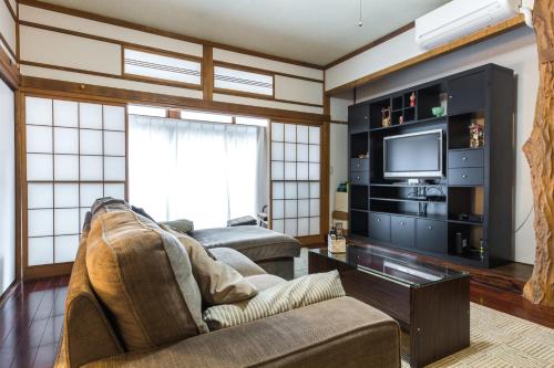 a living room with a couch and a tv at Samurai House - Large Family House, West Shinjuku in Tokyo