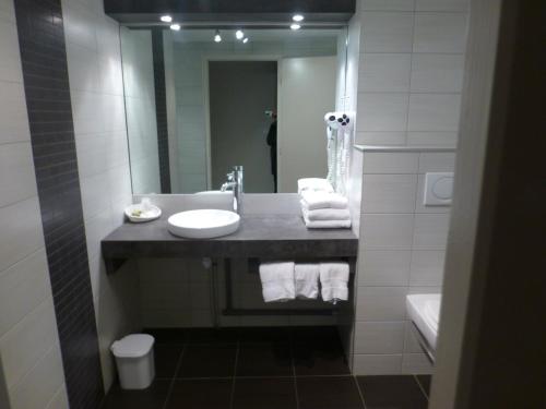 a bathroom with a sink and a mirror at Logis Le Bourguignon in Bèze