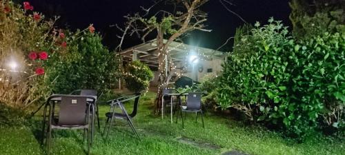 a group of chairs sitting in the yard at night at Casa BRAIS in Barreiros