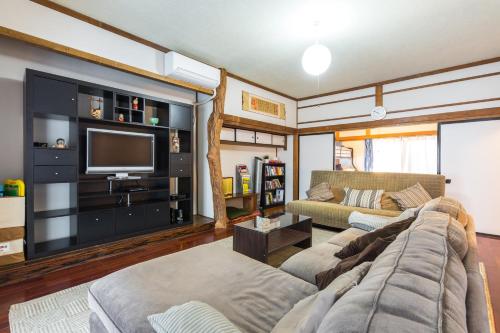 a living room with a couch and a tv at Samurai House - Large Family House, West Shinjuku in Tokyo