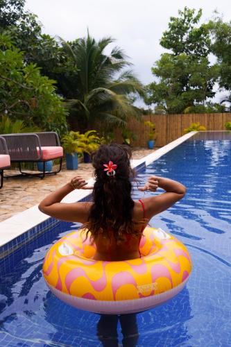 a woman is sitting on a raft in a swimming pool at 9 Bedroom Villa Mui Ne With Private Pool in Mui Ne