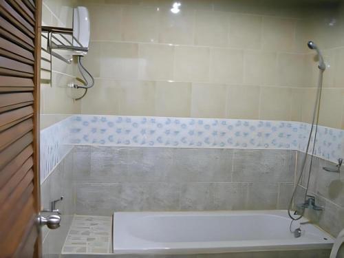 une baignoire dans une salle de bain avec douche dans l'établissement Kamala Phuyai Resort, à Kamala Beach