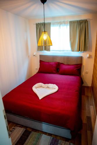 a red bed in a room with a red blanket at Seosko Domaćinstvo Protic , Prijedor , Veliko Palančište in Velika Palančište