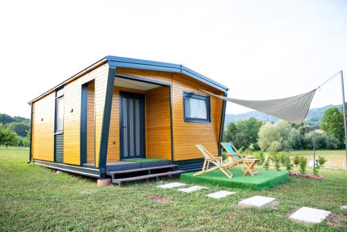 a tiny house in a field with a tent at Seosko Domaćinstvo Protic , Prijedor , Veliko Palančište in Velika Palančište